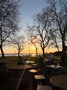 a group of people sitting at tables watching the sunset at Maison La Séréna in Arès