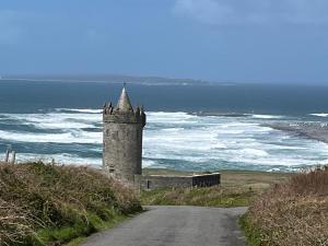 a castle on the side of a road near the ocean at Trá Leathan in Doolin