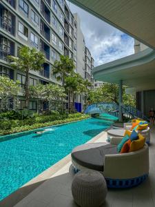 a swimming pool with chaise lounges next to a building at Eden D condo reefB244 in Kathu