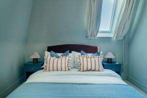 a blue bedroom with a large bed with pillows at St James Apartments - Harrogate in Harrogate
