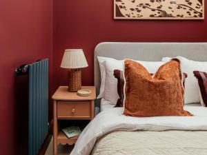 a bed with a pillow and a night stand with a lamp at St James Apartments - Harrogate in Harrogate
