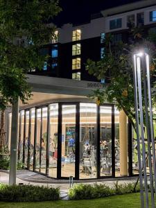 a glass building with people sitting inside of it at night at Eden D condo reefB244 in Kathu