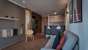 a living room with a blue couch and a kitchen at Marina Dunas in Viña del Mar