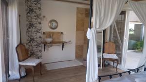 a bedroom with a bed and two chairs and a sink at une halte templière in Trouillas