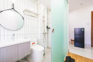 a bathroom with a toilet and a sink and a mirror at La Cheminee Boutique Apartment in Phú Quốc