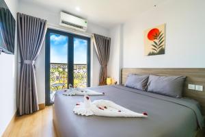 a bedroom with a bed with two swans on it at La Cheminee Boutique Apartment in Phú Quốc +93 photos