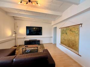 a living room with a couch and a map on the wall at Spektakuläres Turm-Loft mit Aussicht in Braunschweig