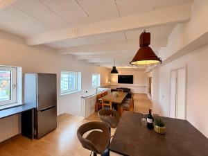 a kitchen and living room with a table and a refrigerator at Spektakuläres Turm-Loft mit Aussicht in Braunschweig +15 photos