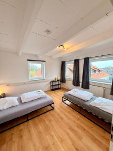 two beds in a room with two windows at Spektakuläres Turm-Loft mit Aussicht in Braunschweig