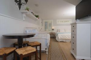 a bedroom with a bed and a table and chairs at Marginal Way House in Ogunquit