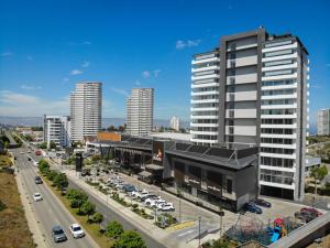 a large building with a parking lot and a highway at Marina Dunas in Viña del Mar
