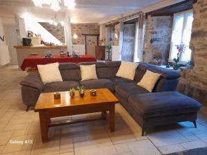 a living room with a couch and a table at LA LONGÈRE - Chambres et table d'hôtes in Alpuech