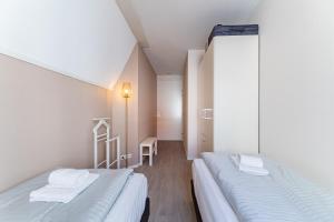 two beds in a room with white walls at Duinhof Klein Dishoek - Appartementen onder aan de duinen, in het centrum met terras in Dishoek