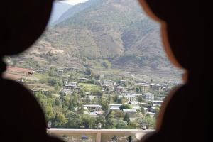 a view of a town from a window of a mountain at Kingaling Hotel in Punākha