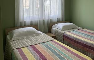 two beds in a small room with a window at Rezidenca Kalter Durres in Golem