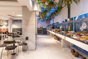 a restaurant with a buffet line with tables and chairs at Hotel Palmas Executivo in Balneário Camboriú