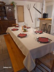 a white table with red napkins and glasses on it at LA LONGÈRE - Chambres et table d'hôtes in Alpuech +20 photos
