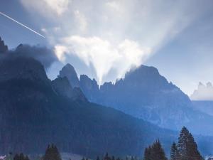 a view of a mountain range with a plane flying over it at Historic Residence Madonna in San Martino di Castrozza