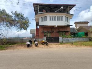 two motorcycles parked in front of a house at coorg mantion homestay in Madikeri +10 photos