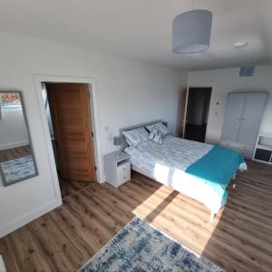a bedroom with a bed and a wooden floor at Beachview Rental in Clare Island +6 photos