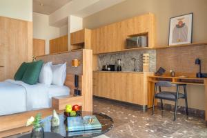 a hotel room with a bed and a desk and a kitchen at NH Guadalajara Studios in Guadalajara