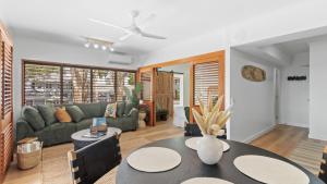a living room with a table and a couch at Absolute Beachfront Palm Cove Apt Sleeps 4 in Palm Cove