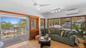 a living room with a couch and a balcony at Absolute Beachfront Palm Cove Apt Sleeps 4 in Palm Cove