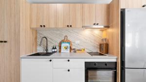 a kitchen with a sink and a refrigerator at Absolute Beachfront Palm Cove Apt Sleeps 4 in Palm Cove +30 photos