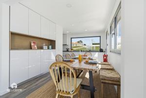 a kitchen and dining room with a table and chairs at Mara Etxea - Villa with pool e Ocean View in Ericeira