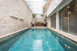 an indoor swimming pool with blue water in a building at Hotel Palmas Executivo in Balneário Camboriú