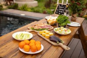 a wooden table topped with plates of food and vegetables at Maia House Homestay in Sóc Sơn