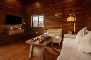 a living room with a couch and a table with a tv at Maia House Homestay in Sóc Sơn