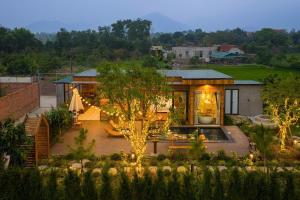 a house with a courtyard with a tree and lights at Maia House Homestay in Sóc Sơn