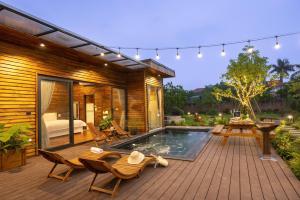 a deck with a pool and chairs and a table at Maia House Homestay in Sóc Sơn