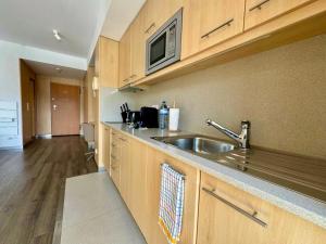 a kitchen with a sink and a microwave at Antas Balcony Studio by LuxiStay in Porto