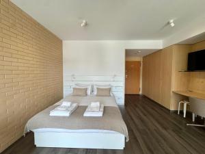 a bedroom with a large bed with towels on it at Antas Balcony Studio by LuxiStay in Porto
