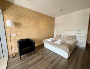 a bedroom with a bed and a black chair at Antas Balcony Studio by LuxiStay in Porto