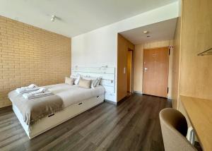 a bedroom with a bed and a brick wall at Antas Balcony Studio by LuxiStay in Porto