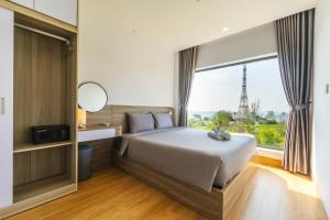 a bedroom with a bed and a large window at La Cheminee Boutique Apartment in Phú Quốc