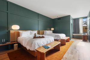 two beds in a room with green walls at Albert Hotel in Fredericksburg