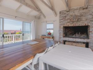 a dining room with a table and a fireplace at Poolstreet 18 in Agulhas