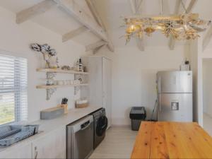 a kitchen with a refrigerator and a wooden table at Poolstreet 18 in Agulhas +2 photos