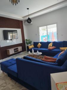 ein Wohnzimmer mit blauen Sofas und einem Tisch in der Unterkunft Djerba Aldo Piscine in Houmt Souk