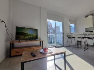 a living room with a flat screen tv and a table at Espectacular departamento en Palermo in Buenos Aires