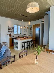 a kitchen and dining room with a table and a kitchen with a counter at Galini House Private Villa in Andros in Órmos +28 photos