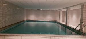 a large swimming pool in a room with a tile wall at Alte Teestube Alte Teestube 14 in Norderney