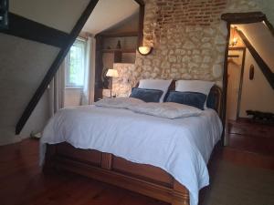 a bedroom with a bed with white sheets and pillows at Chambre d' hôtes Etigue - Etretat in Les Loges