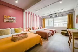 a hotel room with two beds and a couch at Industrial Loft Sukhumvit 3-Bedroom Designer House - 2 Min to BTS Bang Chak in Bangkok