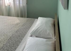 a bed with white pillows on it in a room at Rezidenca Kalter Durres in Golem