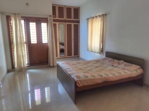 a bedroom with a bed in a room at Three bedroom villa in Mysore